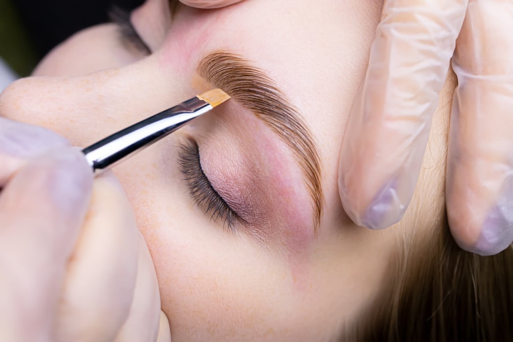 The Eyebrow Lamination Master Holds the Model's Eyebrow and Appl